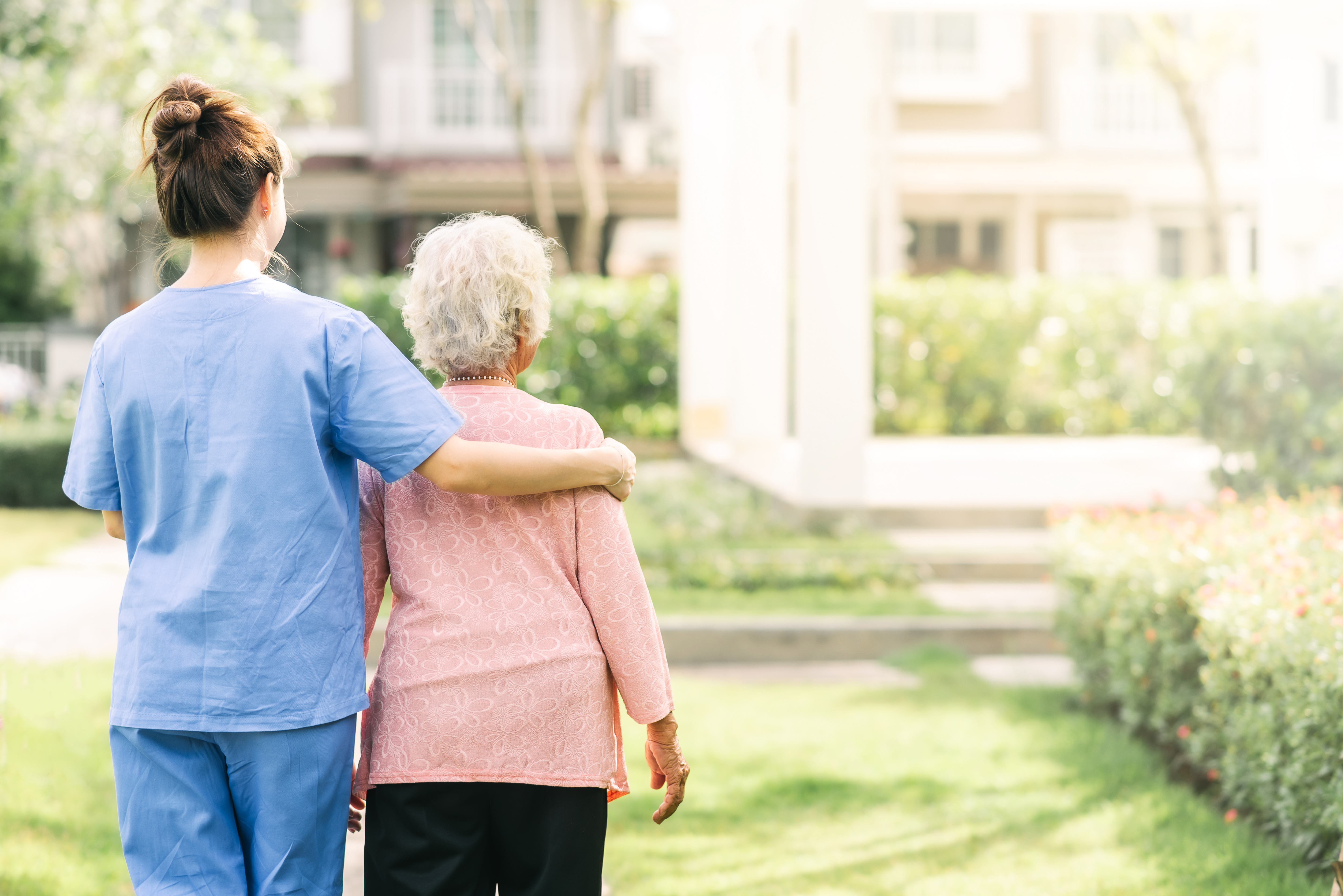 Woman and caregiver walking together