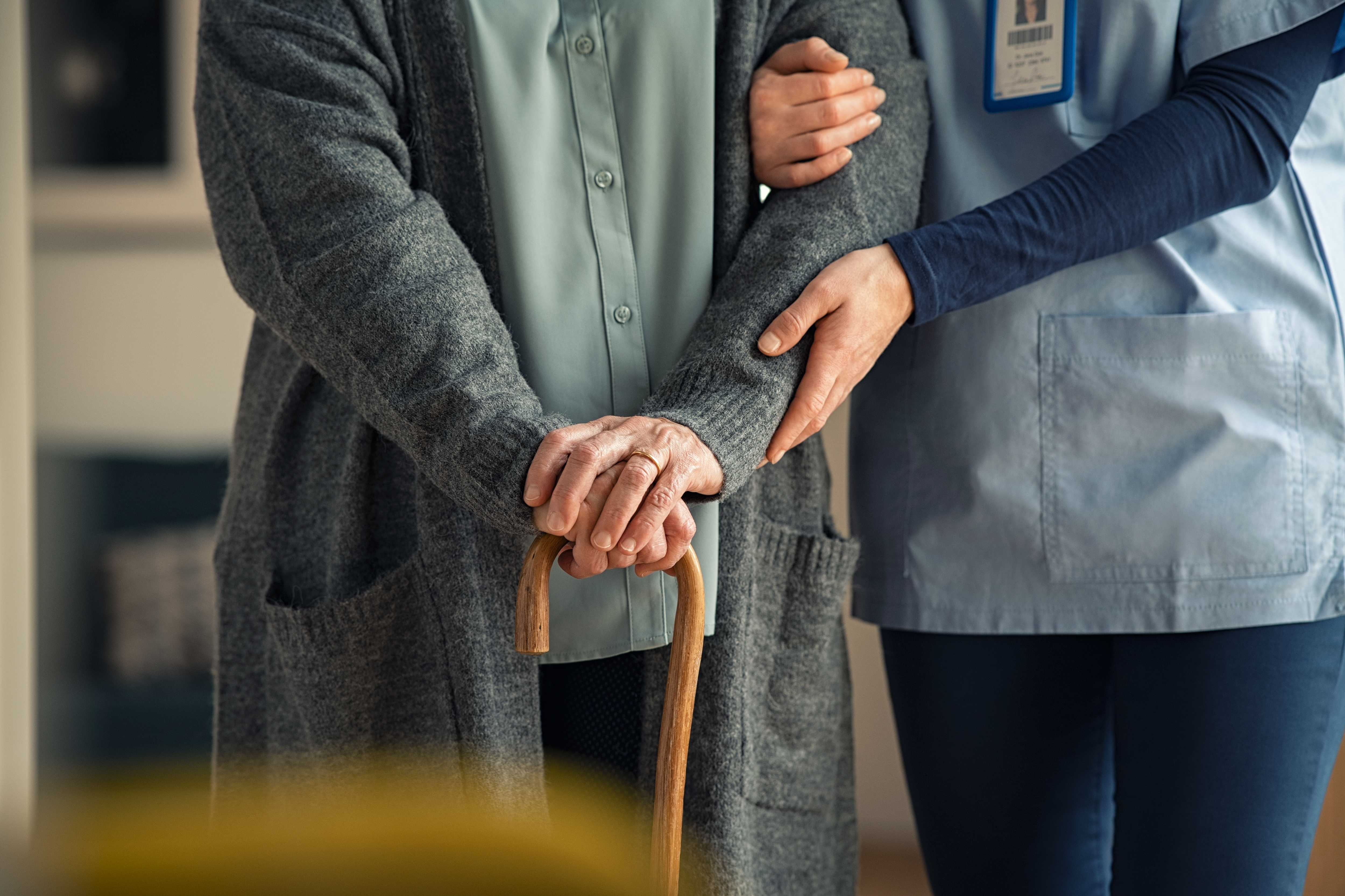 Caregiver helping lady walk
